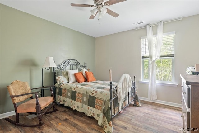 bedroom featuring wood finished floors, baseboards, and a ceiling fan