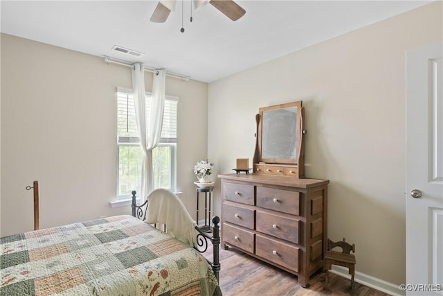 bedroom featuring light wood finished floors, baseboards, and a ceiling fan