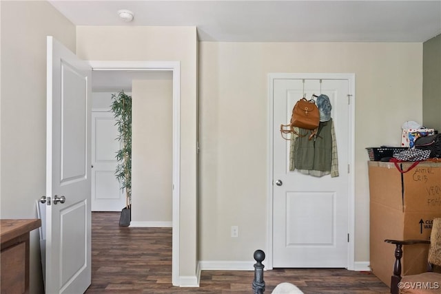 foyer entrance with dark wood-style flooring and baseboards