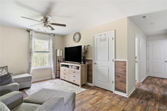 living area with ceiling fan, baseboards, and wood finished floors