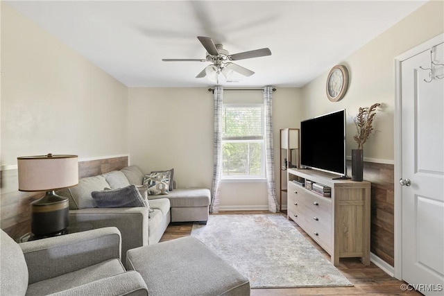 living room featuring ceiling fan, wood finished floors, and baseboards