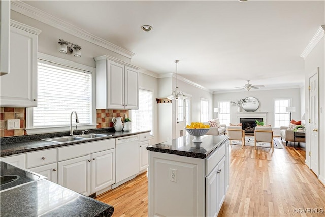 kitchen with dark countertops, dishwasher, a ceiling fan, and a sink