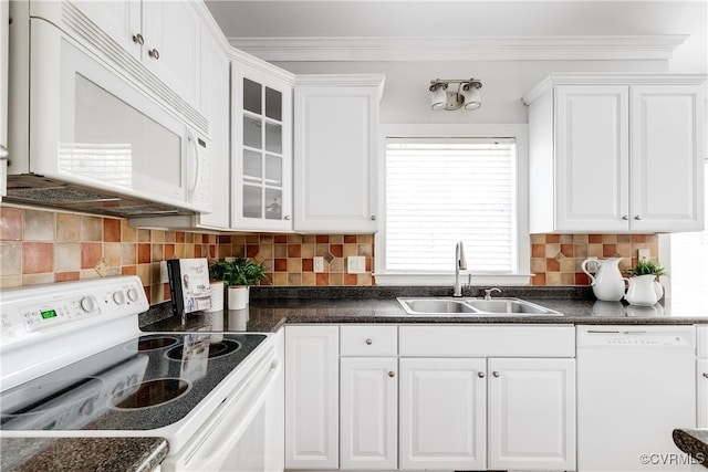 kitchen featuring dark countertops, white appliances, a sink, and white cabinetry