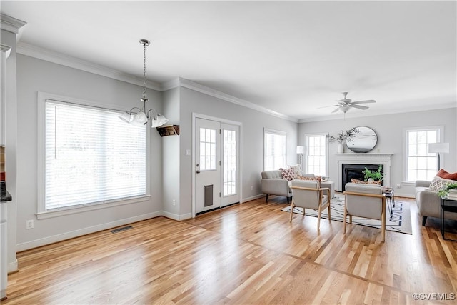 living area featuring a fireplace, light wood-style floors, visible vents, and baseboards