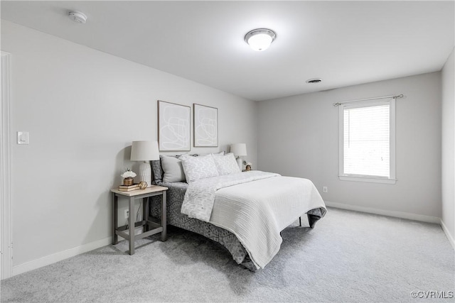 carpeted bedroom featuring baseboards and visible vents