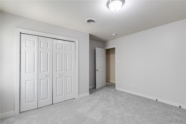 unfurnished bedroom featuring baseboards, visible vents, carpet floors, and a closet