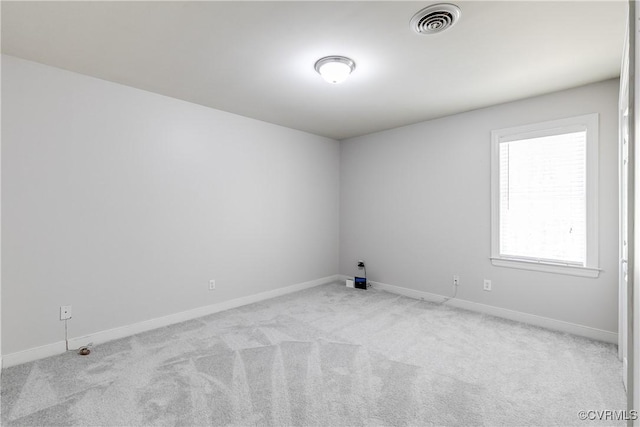 empty room featuring visible vents, carpet flooring, and baseboards