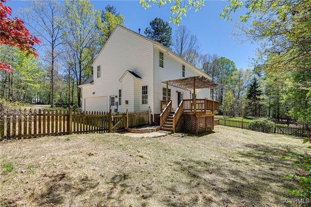 back of house featuring an attached garage, a pergola, a fenced backyard, and a deck