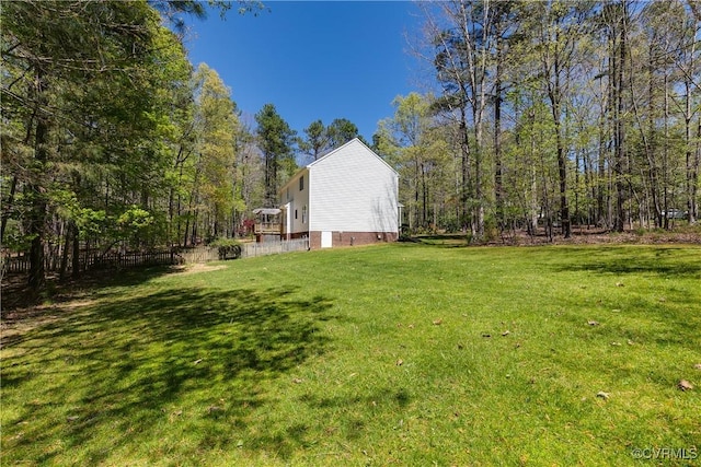 view of yard featuring a forest view and fence