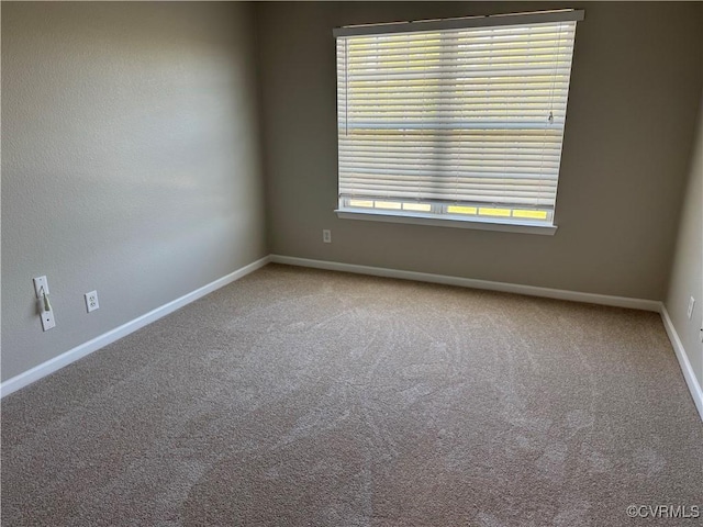 unfurnished room with baseboards and carpet floors