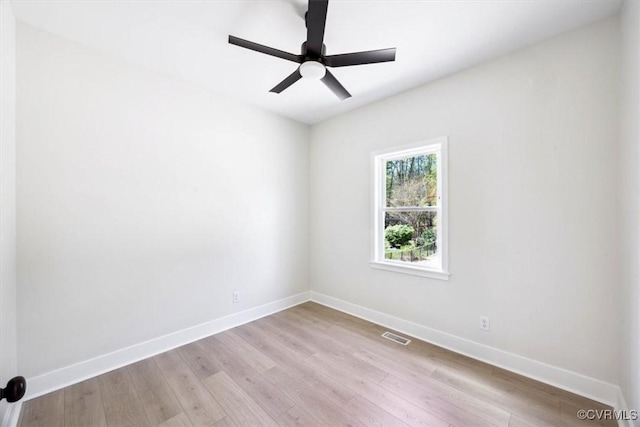 empty room featuring light wood finished floors, a ceiling fan, baseboards, and visible vents