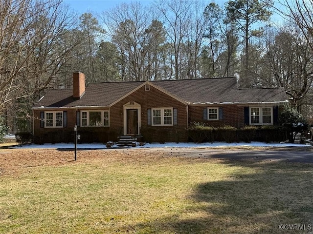 ranch-style house featuring a chimney, a front lawn, and brick siding
