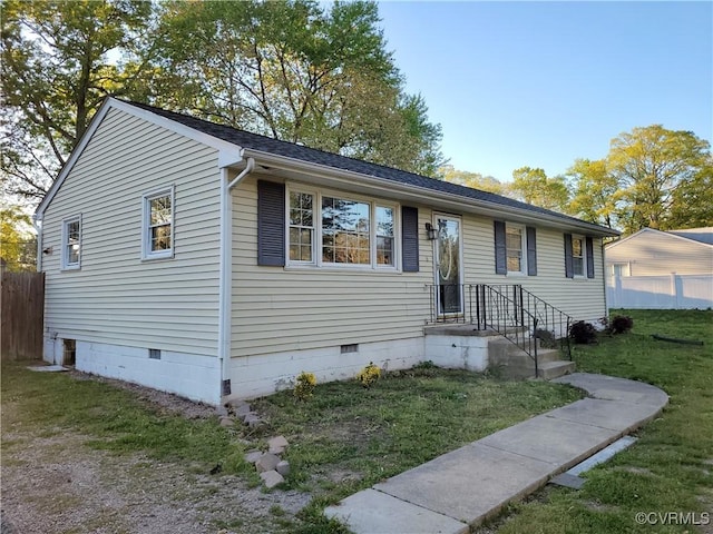 view of front facade with a front lawn, crawl space, and fence