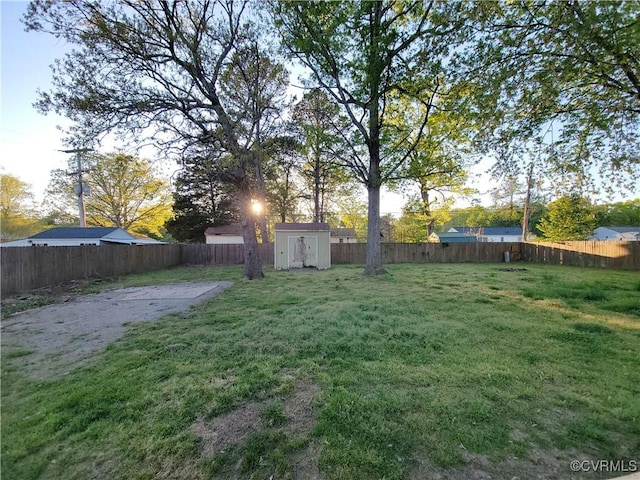 view of yard featuring a storage shed, a fenced backyard, and an outdoor structure