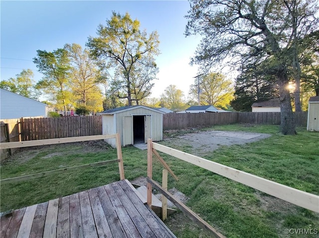 wooden deck featuring a fenced backyard, an outdoor structure, a storage shed, and a yard