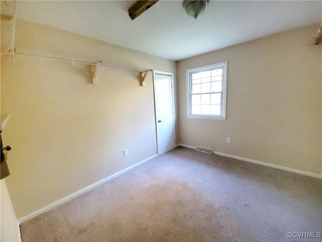 spare room featuring baseboards, visible vents, and carpet flooring