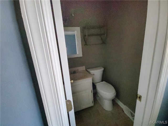 bathroom with baseboards, toilet, and vanity