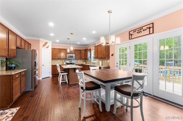dining area featuring recessed lighting, a healthy amount of sunlight, crown molding, and an inviting chandelier