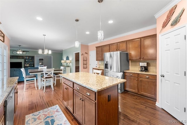 kitchen featuring brown cabinetry, decorative backsplash, pendant lighting, and ornamental molding