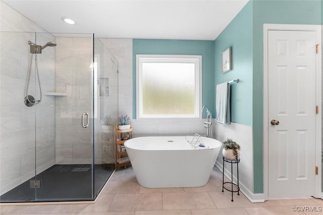 bathroom with a freestanding tub, tile patterned floors, and a stall shower