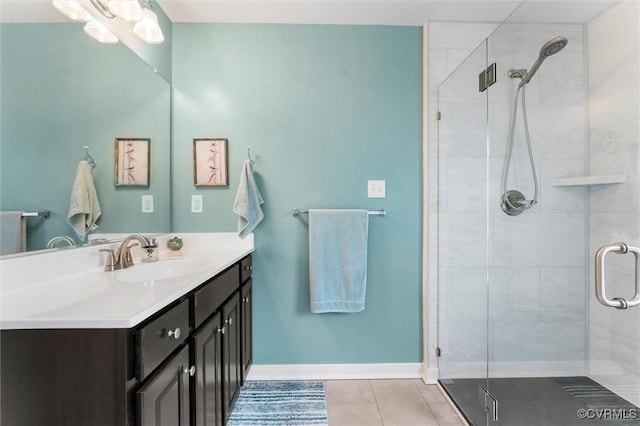 full bath featuring baseboards, vanity, tile patterned flooring, and a stall shower