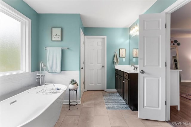 full bath with tile patterned floors, vanity, and a freestanding bath