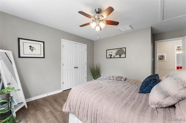 bedroom featuring wood finished floors, a closet, attic access, baseboards, and visible vents