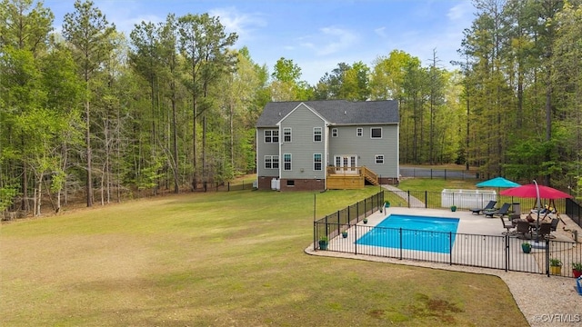 view of swimming pool with a lawn, fence, a patio, a fenced in pool, and a wooden deck