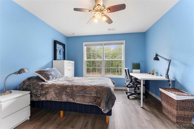 bedroom with ceiling fan, baseboards, wood finished floors, and visible vents