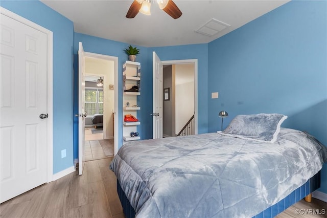 bedroom featuring ceiling fan, baseboards, wood finished floors, and visible vents