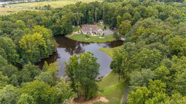 birds eye view of property featuring a forest view and a water view