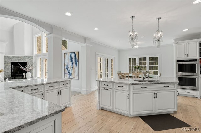 2403 Bermuda Ave, Chester, VA 23836 - kitchen with white cabinets, stainless steel double oven, a sink, crown molding, and a notable chandelier