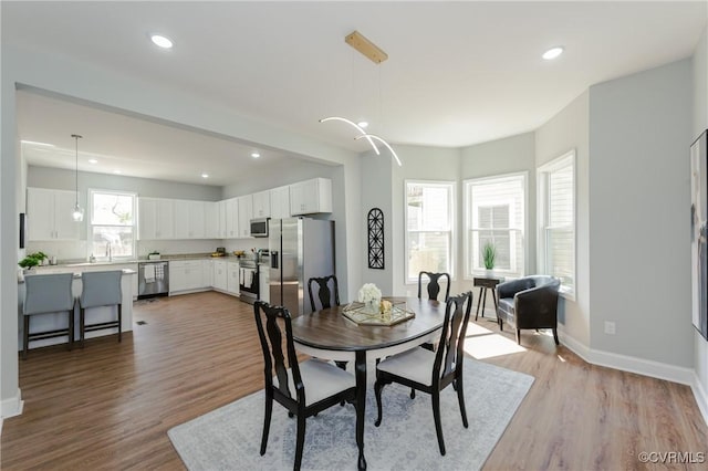 dining area featuring recessed lighting, baseboards, and light wood-type flooring