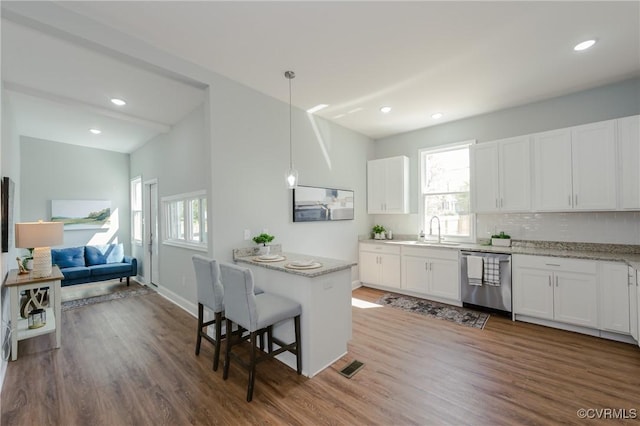 kitchen with dishwasher, a wealth of natural light, a sink, and visible vents