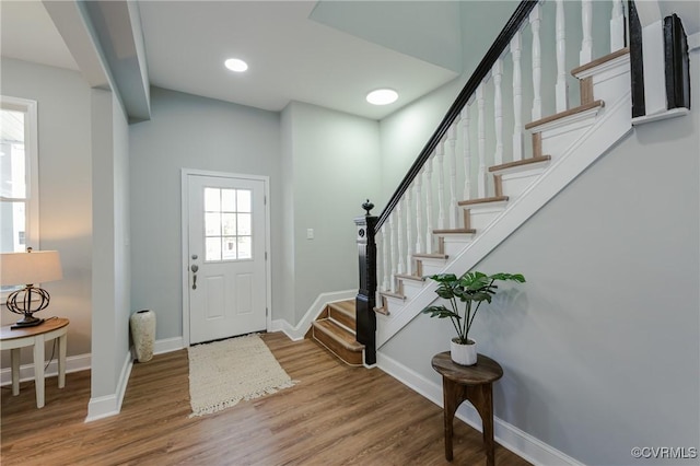 entrance foyer featuring stairs, wood finished floors, and baseboards