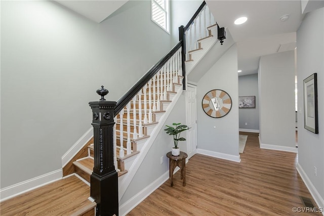 staircase with wood finished floors and baseboards