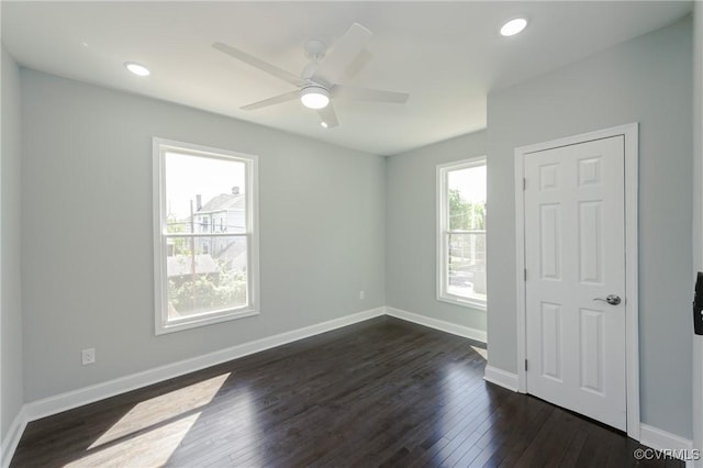 spare room with recessed lighting, ceiling fan, baseboards, and dark wood-style flooring