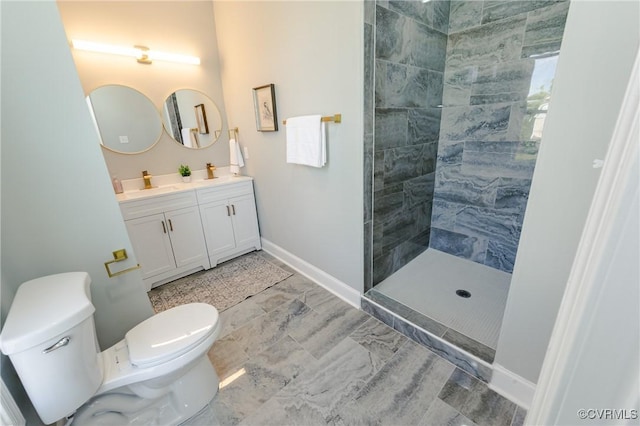 full bathroom featuring a tile shower, toilet, and double vanity