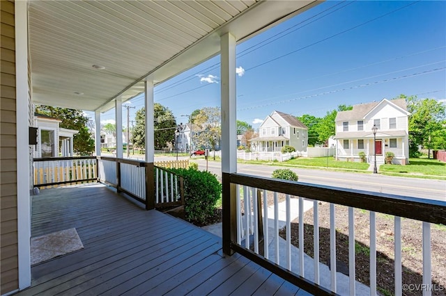 wooden terrace with a residential view and a porch