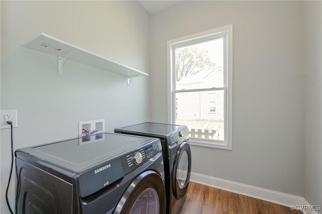 laundry area featuring baseboards, washer and dryer, wood finished floors, and laundry area
