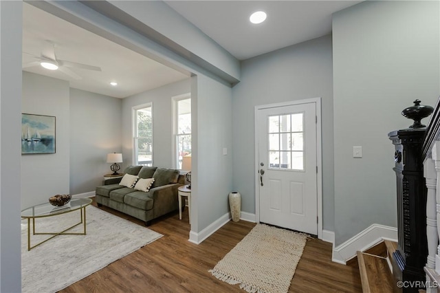 entryway featuring plenty of natural light, a ceiling fan, baseboards, and dark wood-style floors