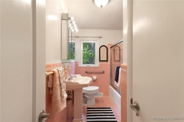 16 Lakeview Dr, Newport News, VA 23602 - full bath with tile walls, tile patterned flooring, a textured ceiling, enclosed tub / shower combo, and wainscoting