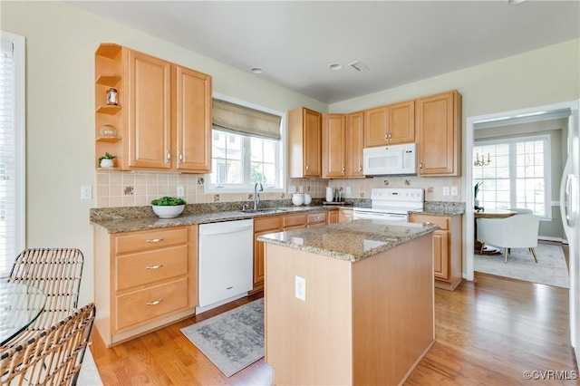 kitchen with light brown cabinets, open shelves, a sink, white appliances, and light wood-type flooring