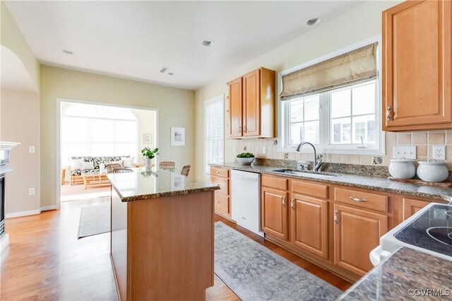 10317 White Marsh Rd, Henrico, VA 23060 - kitchen featuring white appliances, a kitchen island, light wood-style flooring, decorative backsplash, and dark stone countertops