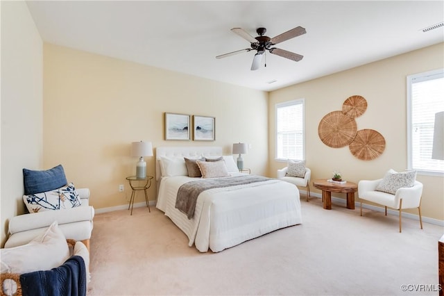 bedroom with visible vents, a ceiling fan, baseboards, and light carpet