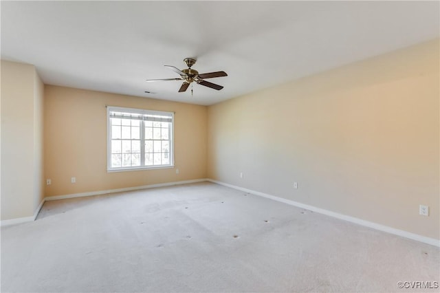 unfurnished room with baseboards, a ceiling fan, and light carpet
