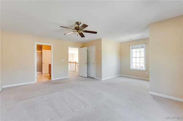 unfurnished bedroom with a ceiling fan, baseboards, light carpet, and ensuite bathroom