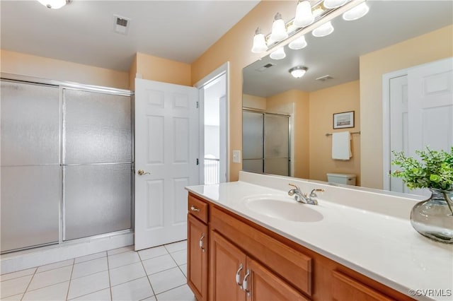 bathroom with vanity, tile patterned floors, visible vents, and a stall shower