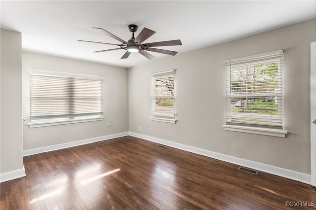 empty room featuring baseboards, wood finished floors, visible vents, and ceiling fan