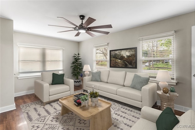 living area featuring baseboards, a ceiling fan, wood finished floors, and a healthy amount of sunlight